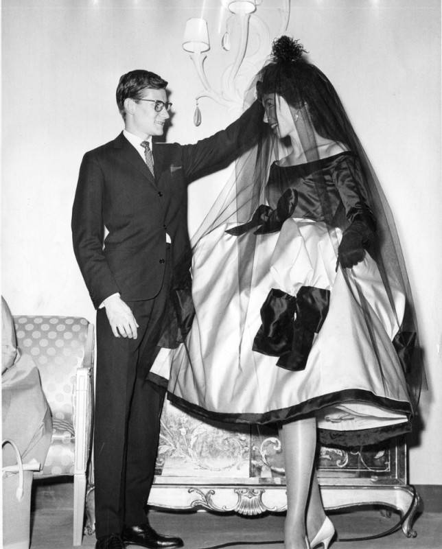 Yves Saint Laurent adjusting the veil of a model wearing Laykin et Cie jewels at an I. Magnin fashion show, Ambassador Hotel, Los Angeles, 1958