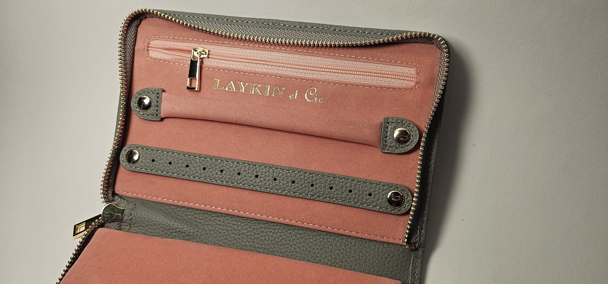 The Laykin Leather Valise interior — gray leather straps and compartments over signature pink suede
